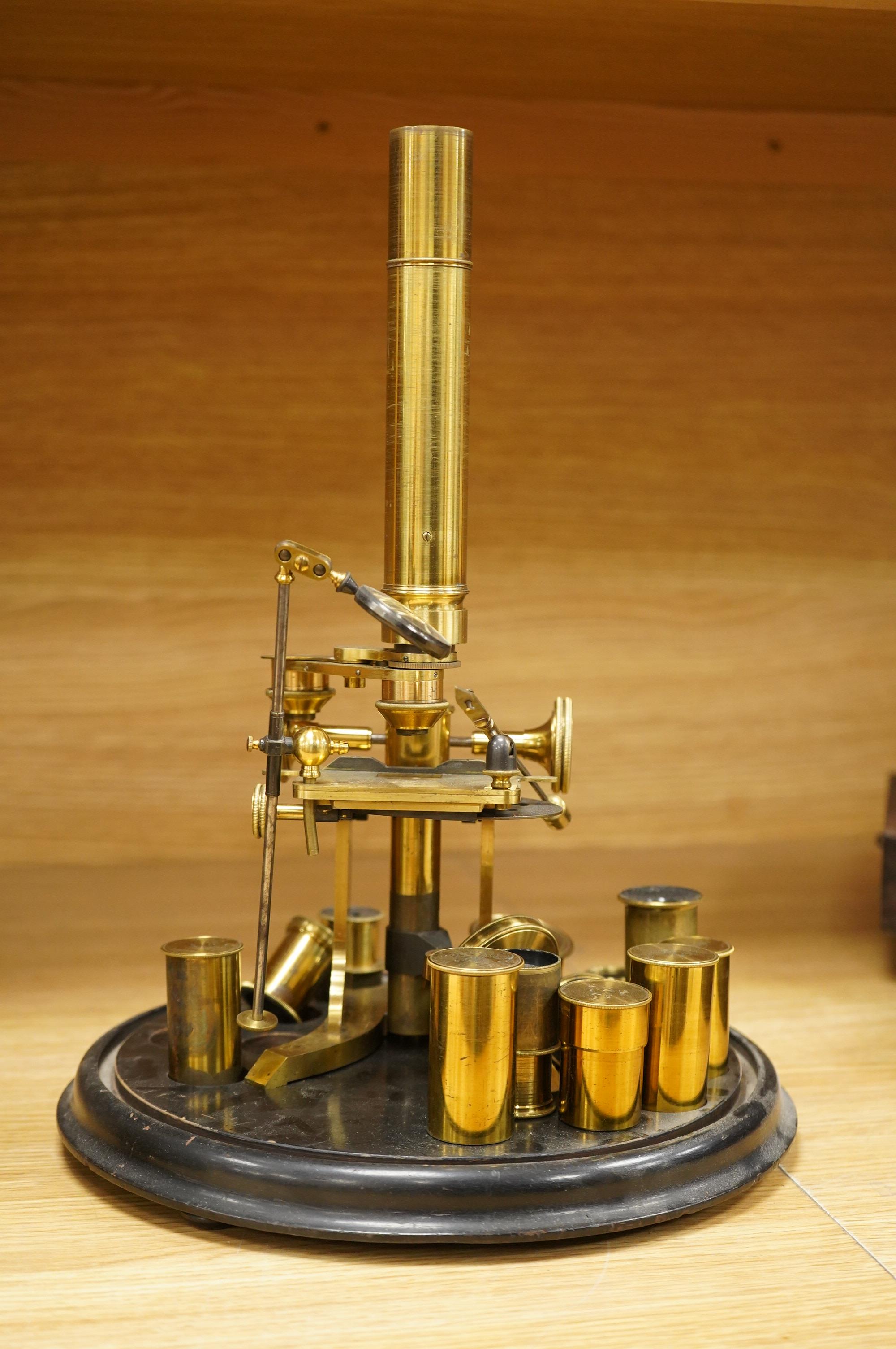 A mid 19th century brass monocular microscope, unsigned, with five objectives and three eyepieces, together with a Lieberkühn, a dark spot substage condenser, and a pair of Nicols prisms